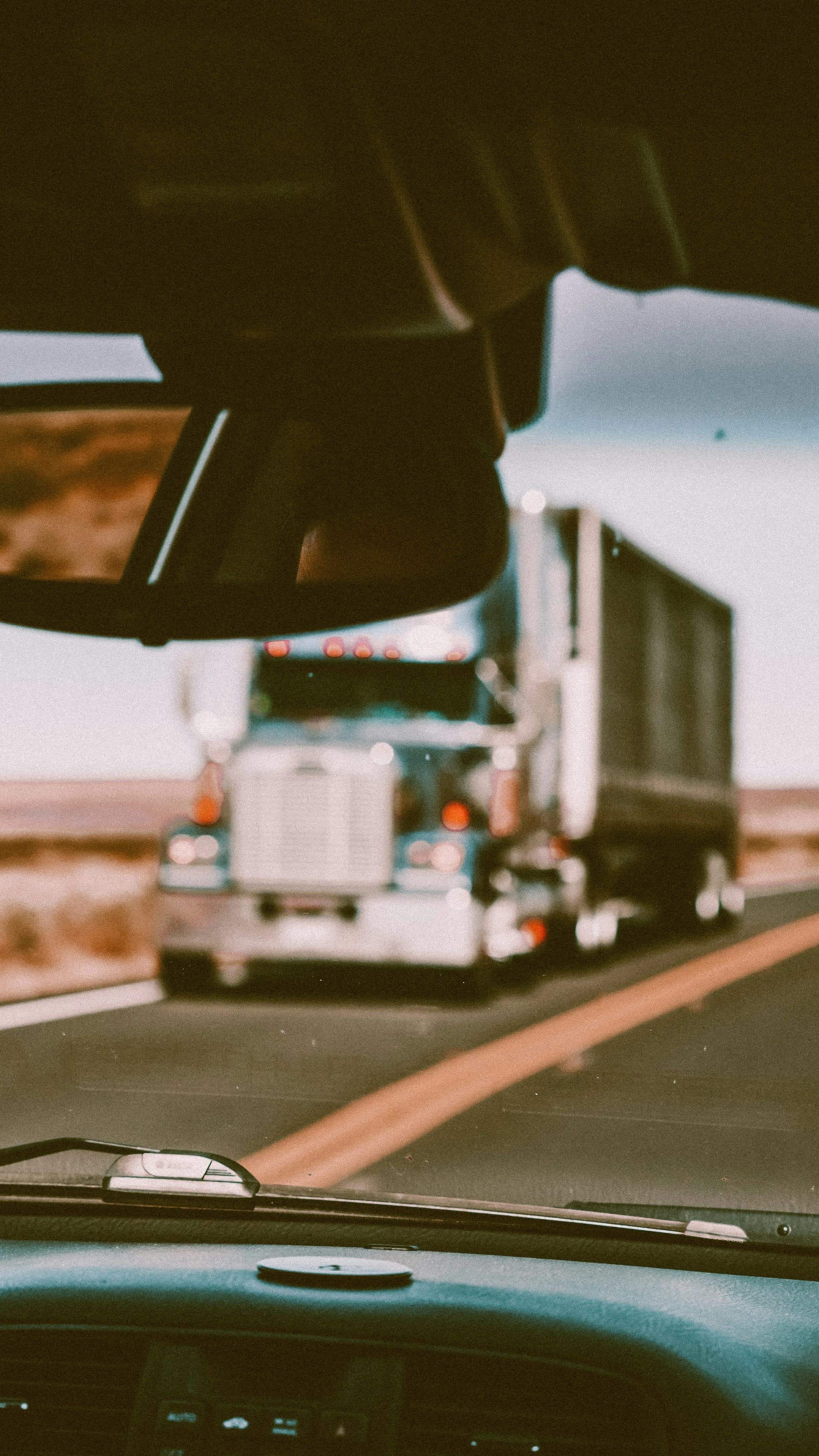Freight truck seen through a vehicle windshield on the open road