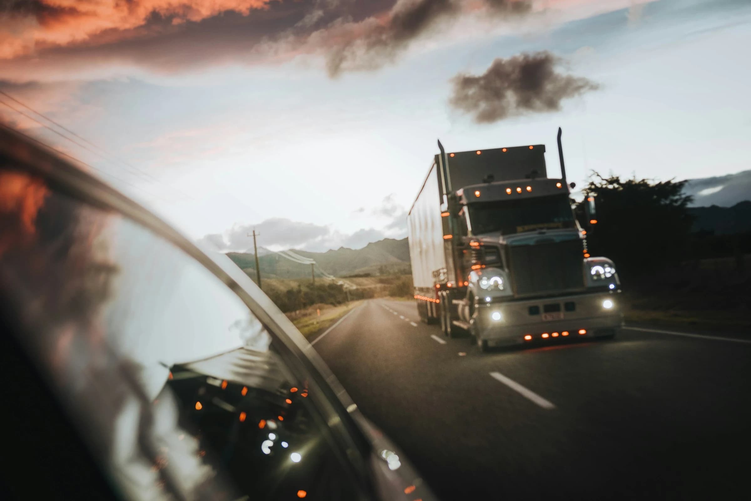 Semi truck on a highway at dusk, seen from a following vehicle